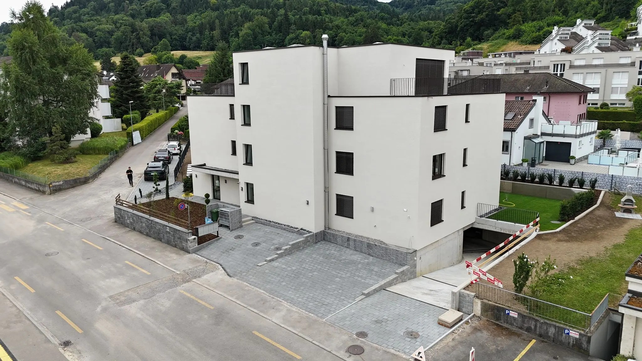 Strassenseite mit Zufahrt zur Einstellhalle