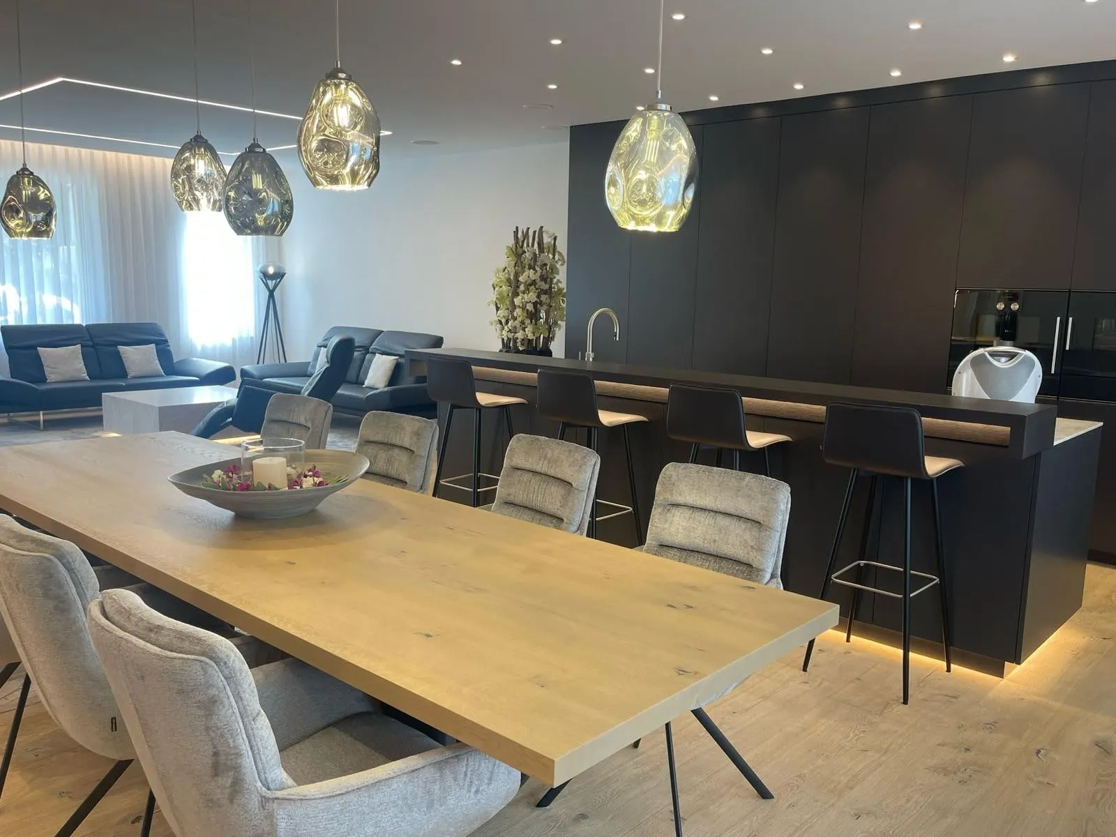 Esstisch mit Leuchten und beleuchteter Bar