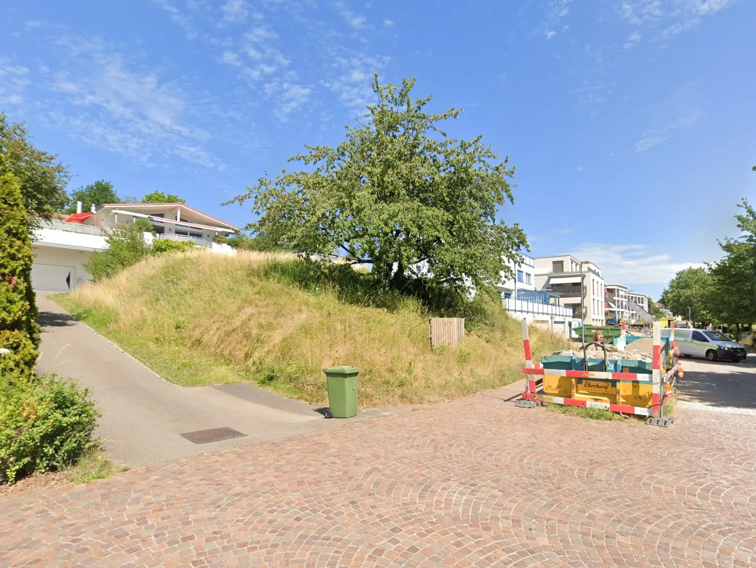 Parzelle mit Böschung und Bäumen, Blick von der Strasse vor Baubeginn